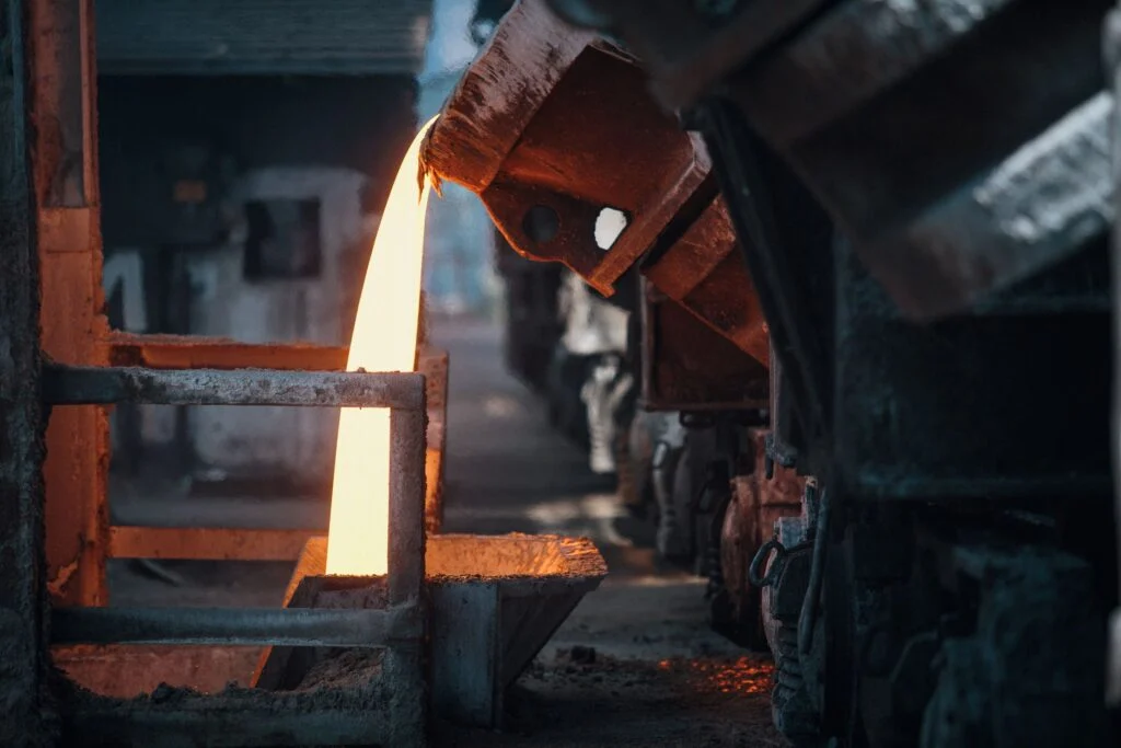 Metal fundido cayendo de la cuchara en una fundición